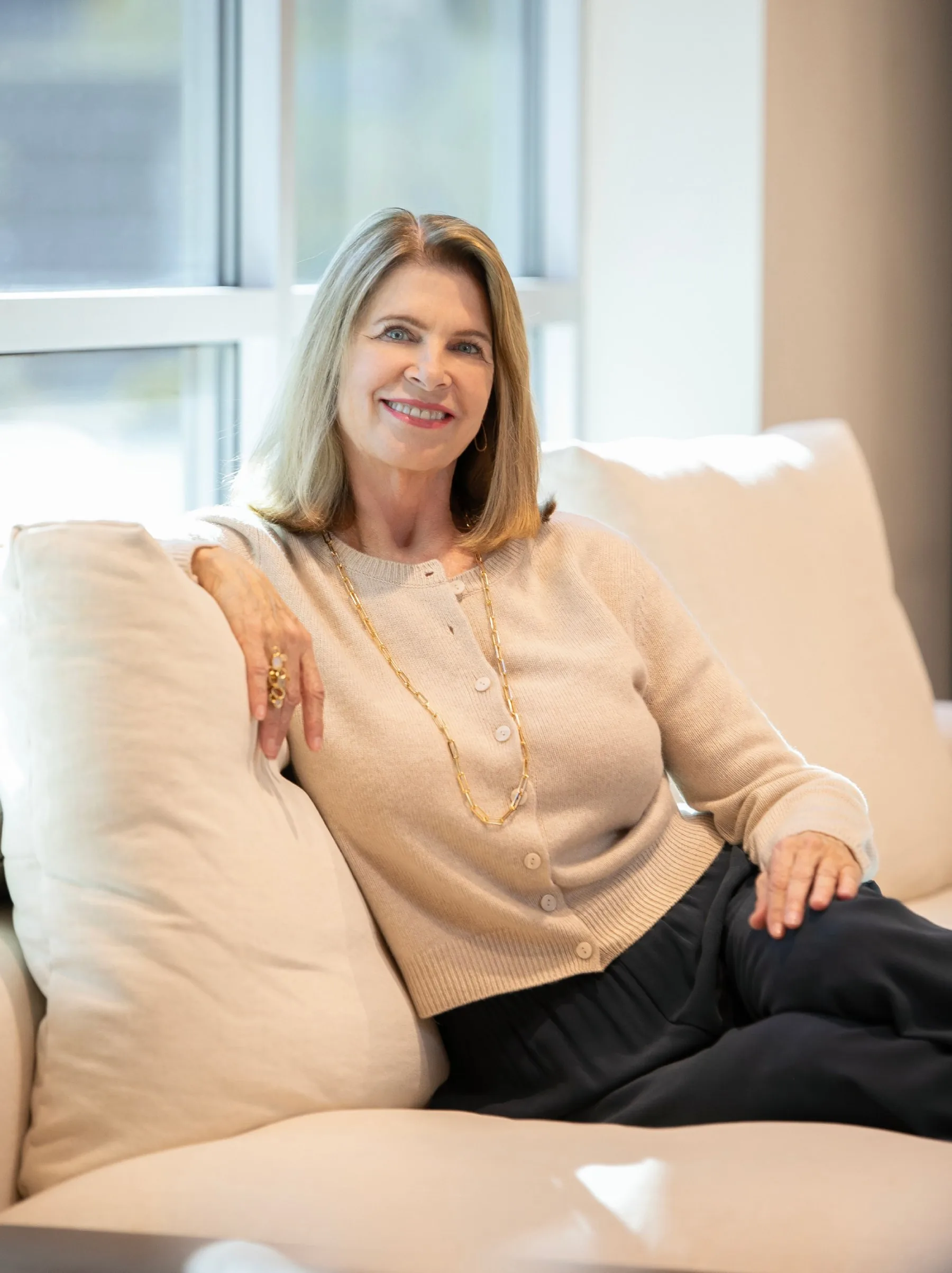 Lauren Jacobsen, principal designer, seated on a cream sofa